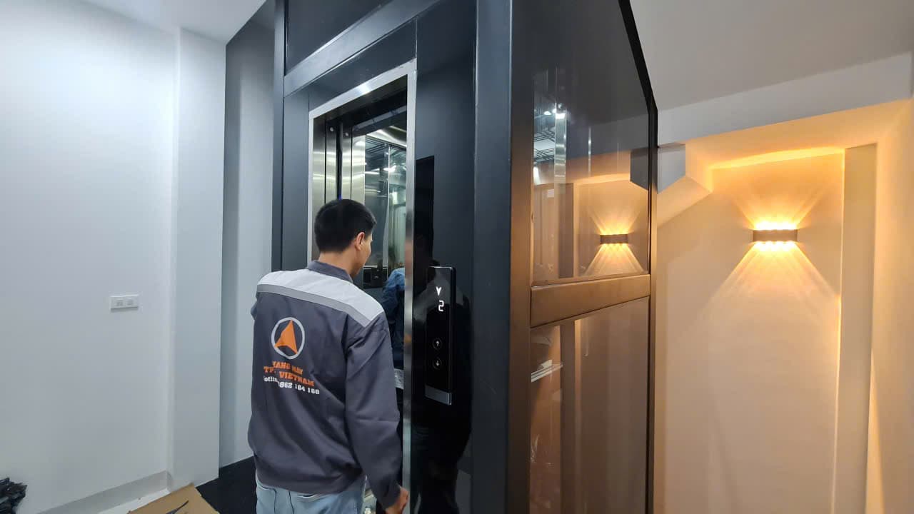 Kỹ thuật viên TPEC mở cửa cabin thang máy kính cạnh vách đèn trang trí, nhà phố Hà Đông