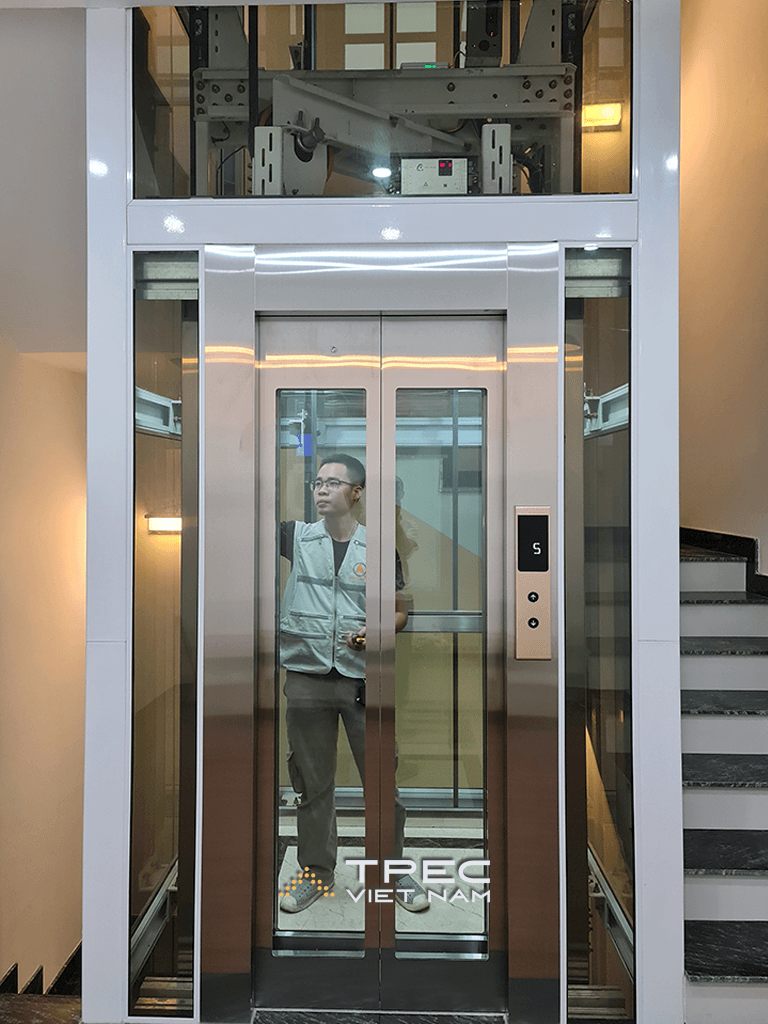 Cận cảnh cửa cabin thang máy kính inox hồng, khung trắng, dự án Him Lam Vạn Phúc
