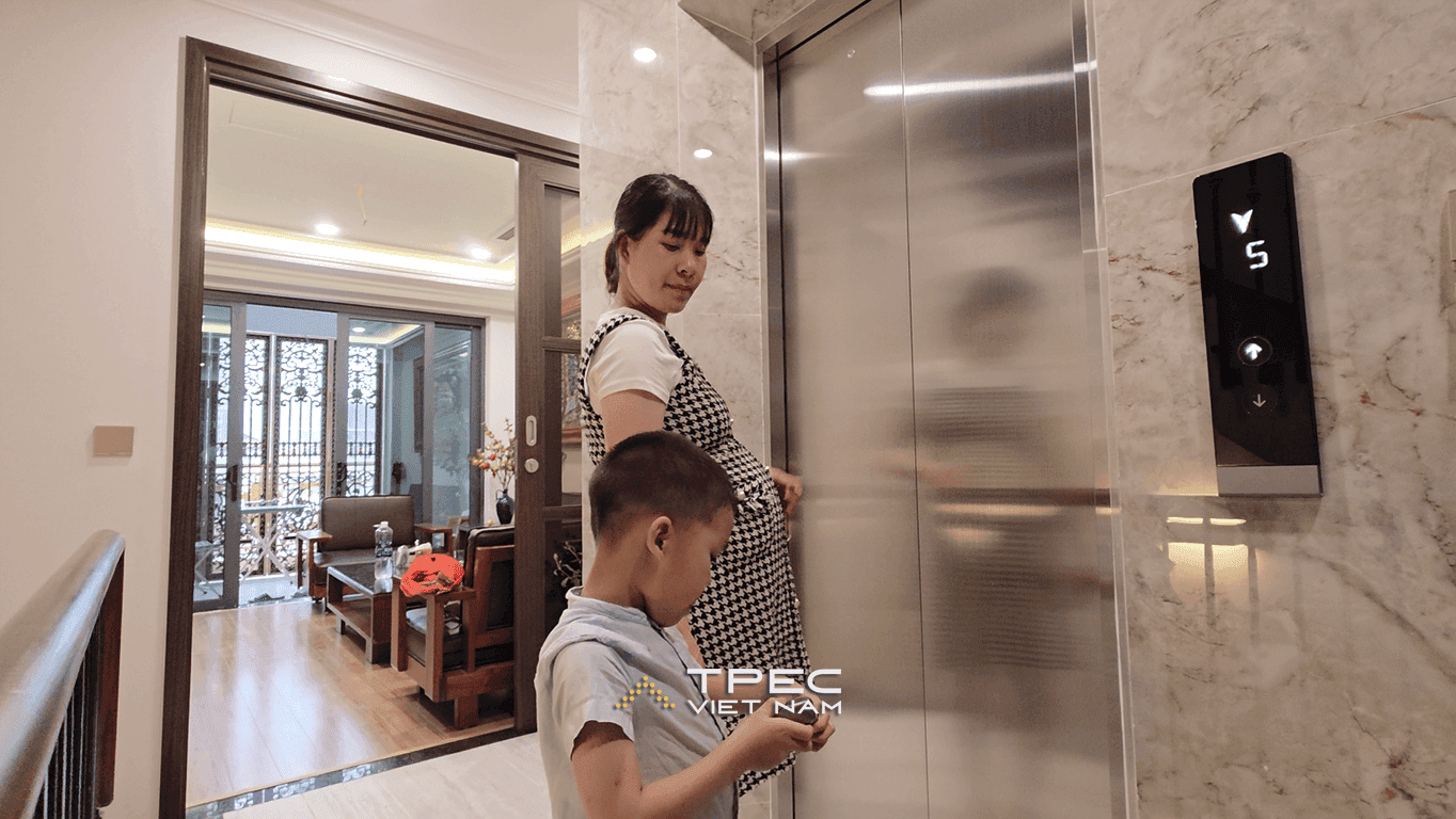 Mẹ và bé chờ thang máy gia đình bên sảnh ốp đá nhà phố Nguyễn Công Hoan