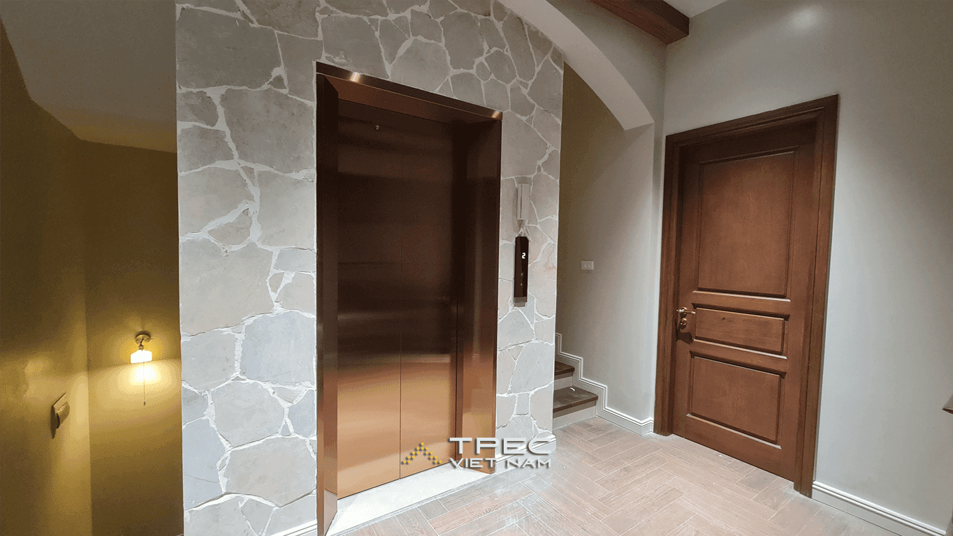 Cửa tầng thang máy inox đồng ốp đá tổ ong cạnh cầu thang biệt thự 450kg