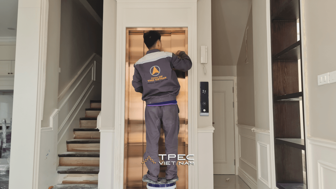 Kỹ thuật viên TPEC bóc lớp nylon bảo vệ cửa thang máy tại biệt thự Xanh Villas Thạch Thất