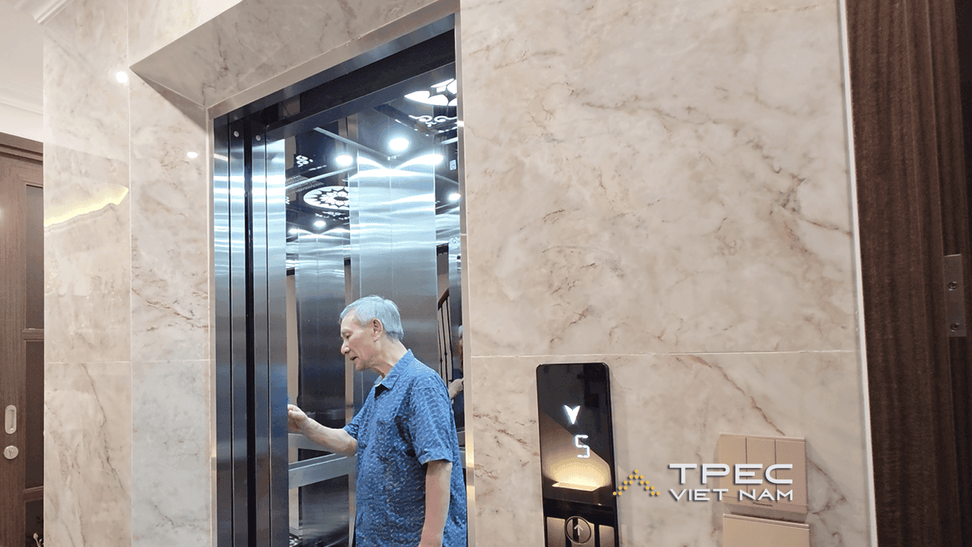 Người cao tuổi bấm nút gọi thang máy gia đình bên sảnh ốp đá phố Nguyễn Công Hoan