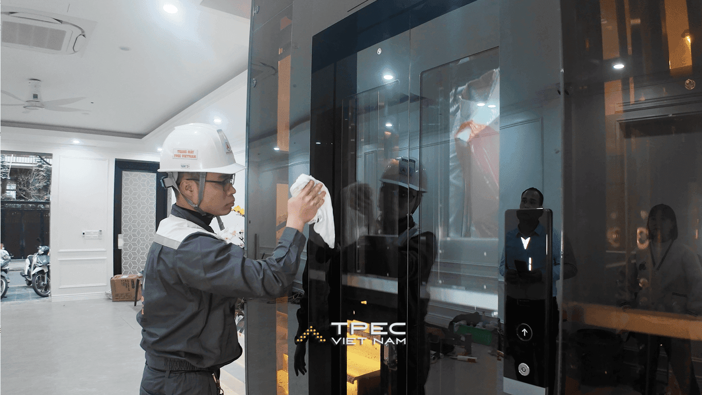 Kỹ thuật viên TPEC lau kính thang máy trước khi bàn giao cho khách tại nhà phố Trung Kính