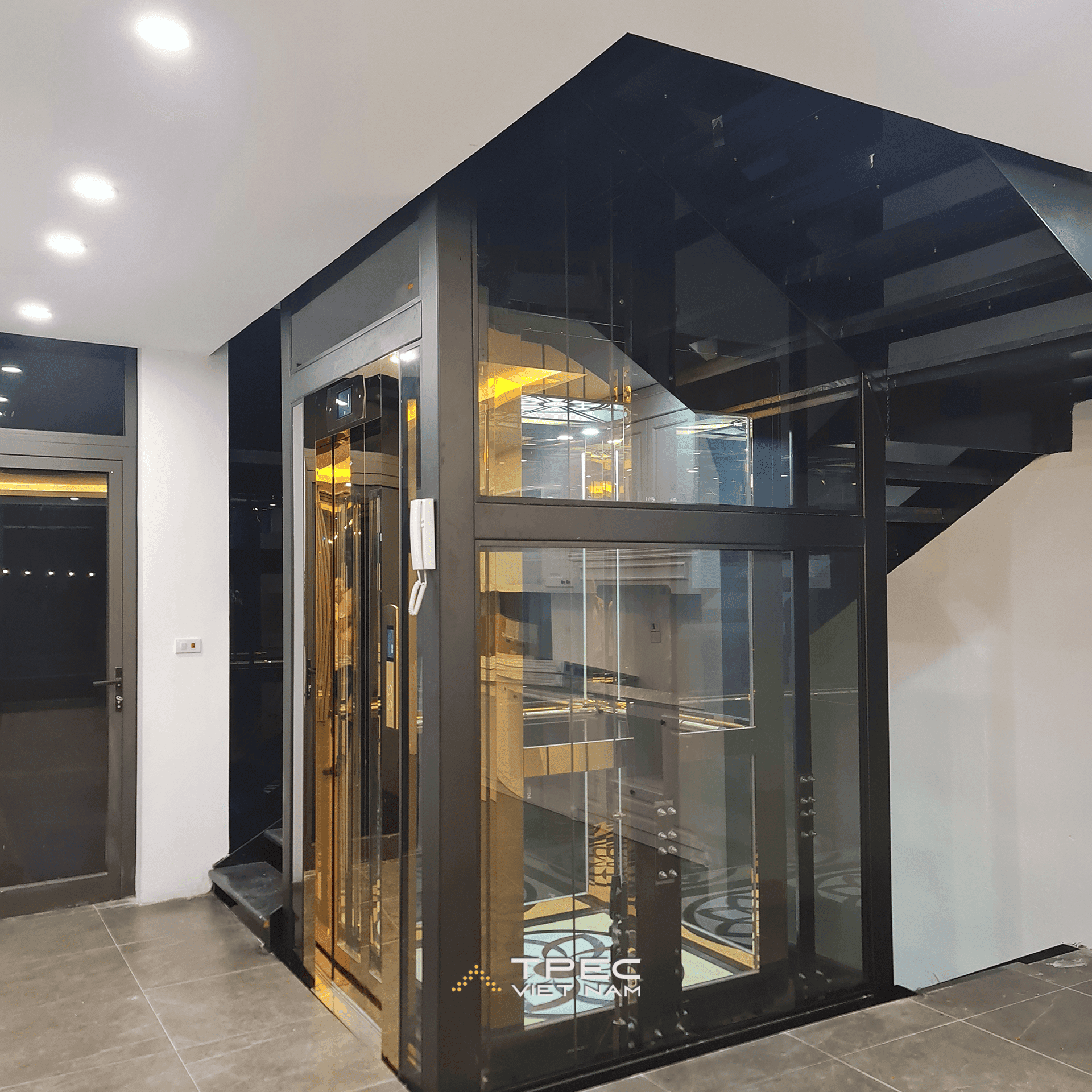 Cửa cabin inox gương vàng thang máy kính 630kg đặt cạnh cầu thang sắt, dự án tại Sơn Tây