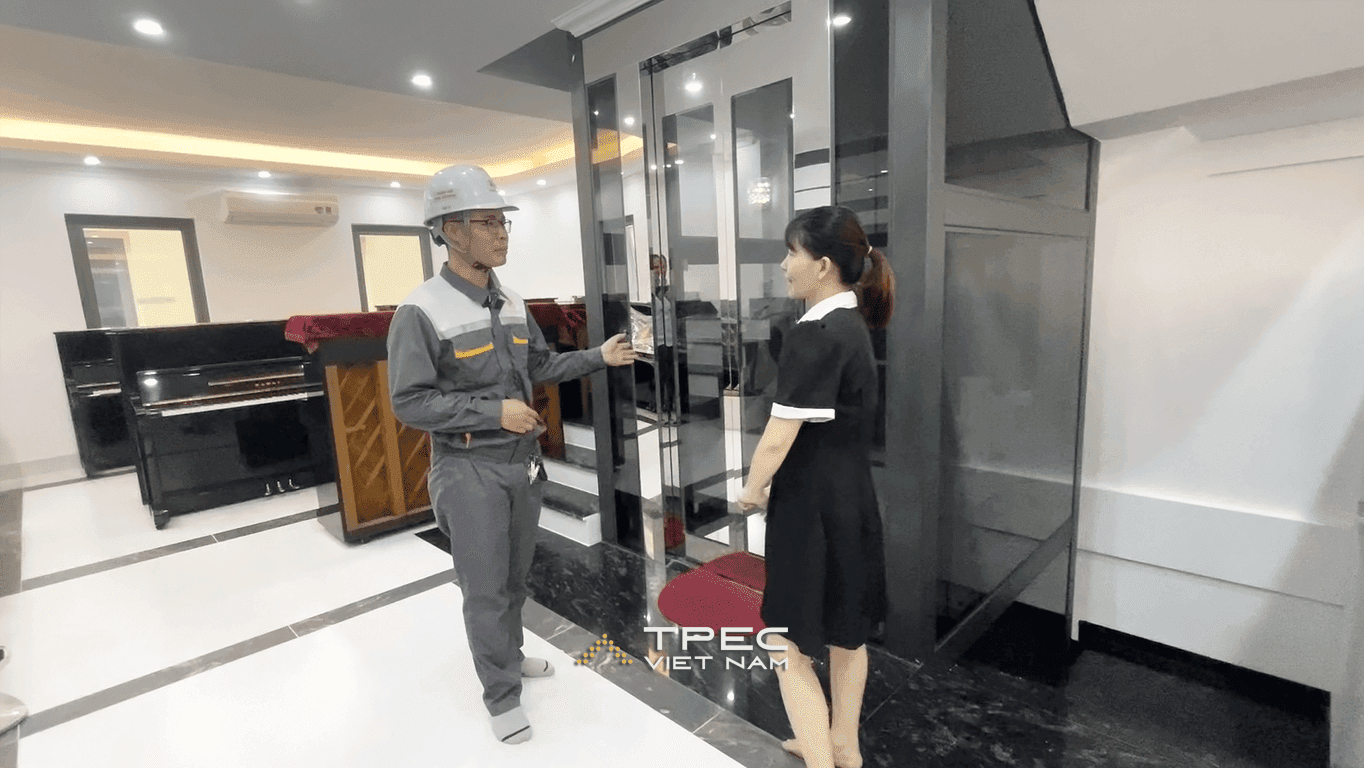 Kỹ thuật TPEC bàn giao thang máy kính giếng khung đen trong showroom piano Hà Nội