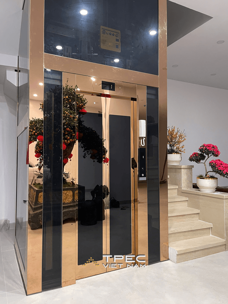 Thang máy kính gia đình khung ốp inox gương đồng lắp tại nhà phố Trần Quang Diệu