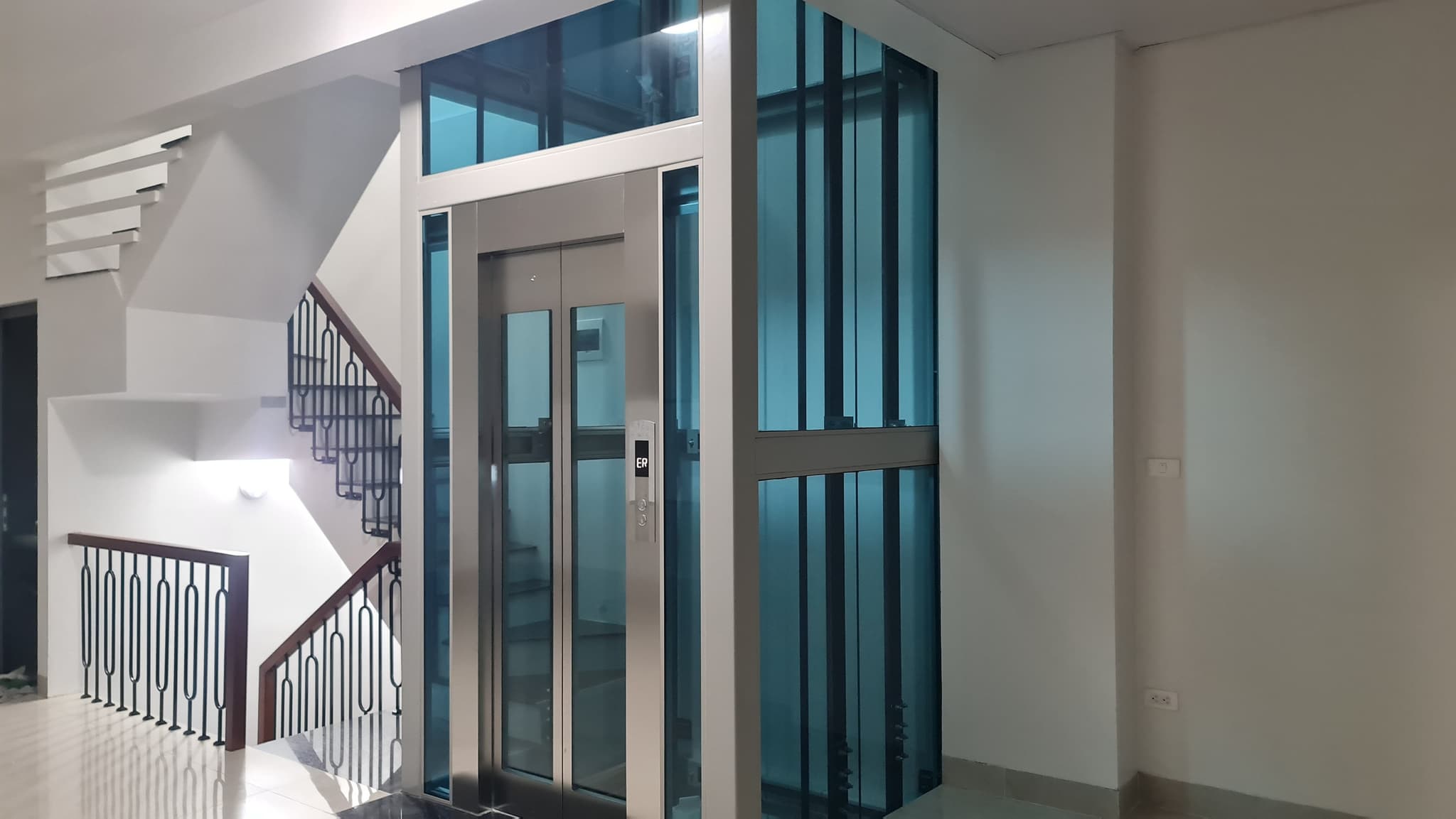 Thang máy kính 450kg khung nhôm vách kính xanh, cabin inox cạnh cầu thang, nhà phố Hạ Đình