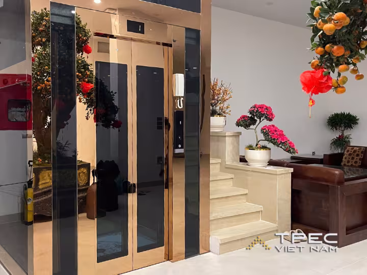 Dự án thang máy kính khung bọc inox gương đồng sang trọng